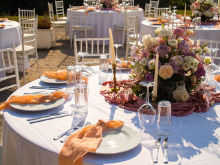 Beautiful outdoor wedding decoration in city. Candles and dried flowers and accessories with bouquets and glasses on table with linen tablecloth on newlywed table on green lawn