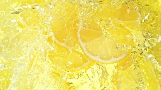 Super Slow Motion Shot of Fresh Lemon Slices Falling into Water Whirl at 1000 fps.