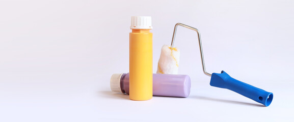 Interior renovation paint. Paint in plastic bottles and paint roller on a white background. Free space for text. Two bottles of acrylic paint, photo for banner