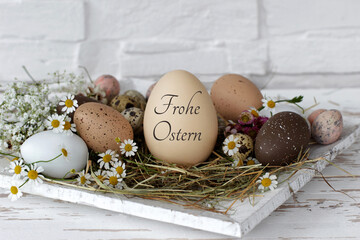 Grußkarte Frohe Ostern: Harmonische Osterdekoration mit Ostereiern in einem Nest, davon eins mit...