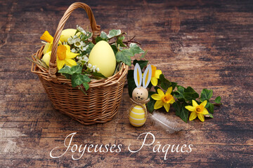 Panier de Pâques décoratif avec jonquilles, lierre et un œuf de Pâques inscrit avec le texte...