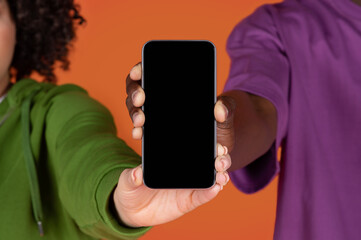 Unrecognizable multiracial couple holding phone with blank screen