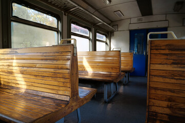 Old empty wagon of train. Wooden seats in an empty coach of train