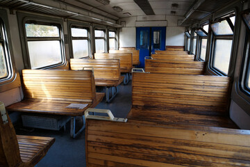 Old empty wagon of train. Wooden seats in an empty coach of train