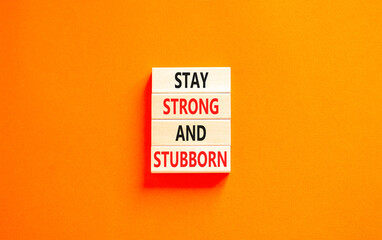 Stay strong and stubborn symbol. Concept words Stay strong and stubborn on wooden block. Beautiful orange table orange background. Motivational business stay strong and stubborn concept. Copy space.
