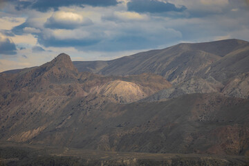 Arid treeless mountains during the day with spectacular clouds
