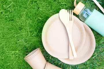 Zero waste concept, disposable tableware over green grass