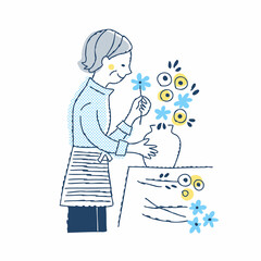 花瓶に花を生けているシニア女性