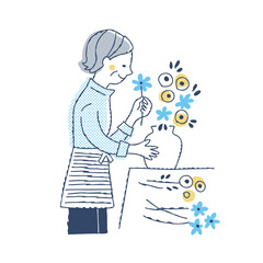 花瓶に花を生けているシニア女性