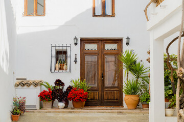 Exterior of a beautiful Mediterranean house, with white walls, decorated with plants and flowers, on a sunny day in Altea La Vella, (Alicante, Spain).