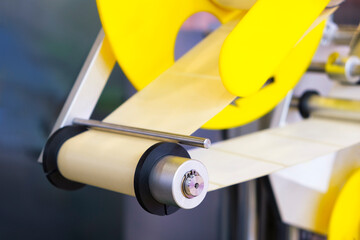 Fragment of the conveyor of sticking labeling machine. Abstract industrial background.