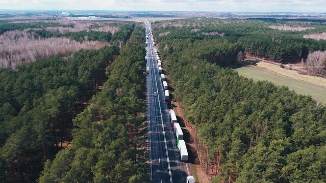 A line of trucks at the border along the road. Waiting while transporting goods.