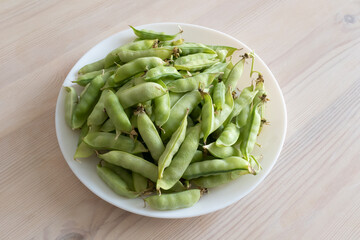 peas in pods on a white plate