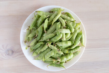 peas in pods on a white plate