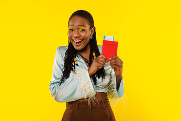 Joyful African Lady Holding Passport And Tickets On Yellow Background