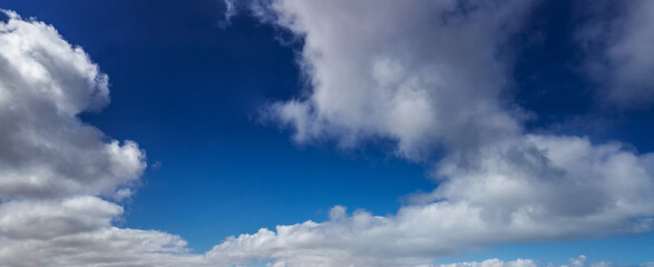 Błękitne niebo z białymi chmurami. Naturalne niebo jako tło. Piękne białe chmury na niebieskim niebie. Tekstura tło. Panoramicznie