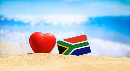I love South Africa. Flag of South Africa on the beach with a red heart. vacation and travel concept.