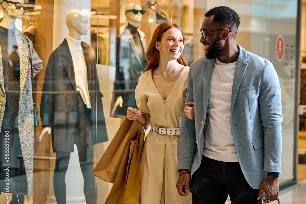 Sticker happy wife and husband spend their weekend at shopping mall. close up side view photo, cheerful couple strolling at shopping center , good mood, positive atmosphere between lovers