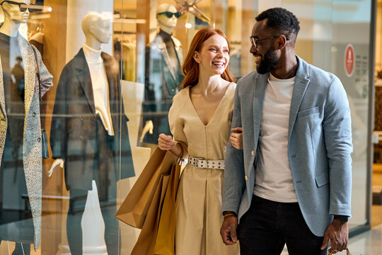 happy wife and husband spend their weekend at shopping mall. close up side view photo, cheerful couple strolling at shopping center , good mood, positive atmosphere between lovers
