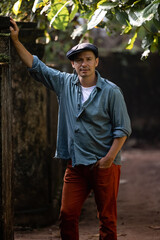 Obraz premium An attractive man in a hat and red pants is looking at the camera. Handsome male