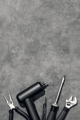 Naklejka premium Flat lay composition with set of home repair tools on grey stone background. Top view pattern with copy space.