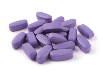 Obraz na płótnie Canvas Purple pills on white background, close-up