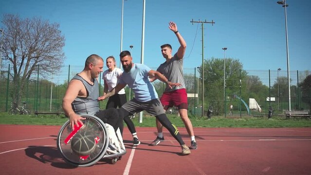 A physically challenged person play street basketball with his friends.	
