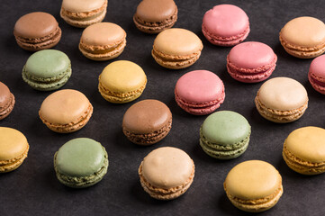 Sweet colorful macarons dessert on a black background