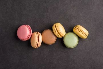 Foto op Canvas Sweet colorful macarons dessert on a black background © buffalo