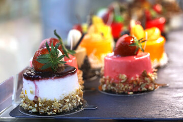 Cakes with fresh berries, selective focus. Sweet desserts with strawberry and cream in cafe showcase