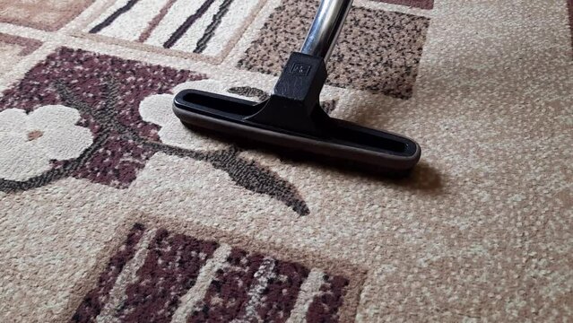 Close up of the vacuum cleaner, focus on the brush, cleaning the carpet. Home, housekeeping concept. 
