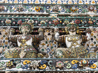 2 decorative, colorful statues on the facade of Wat Arun in Bangkok, Thailand.