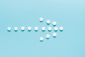 Medicine pills on a blue. Close up of white round pills with pharmacy and medical concept. Flat lay, top view.	