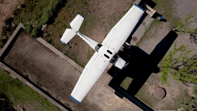 Ascending orbital top view of a display abandoned single-engine small plane in Alcublas, Los Serranos Region, Spain
