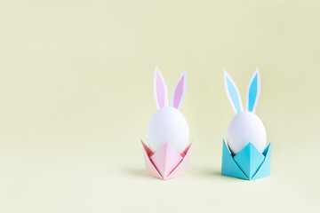 Easter eggs with handmade paper ears on yellow background. Nature concept.