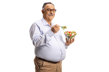 Mature man standing and eating a salad