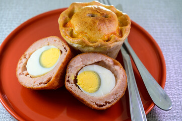 Traditional street food in UK, stuffed fried Scotch eggs with breadcrumbs and baked pie with pork meat