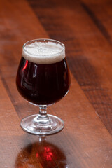 Glass of Belgian abbey red brown beer on table