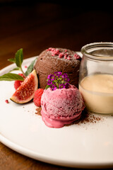 selective focus on ball of ice cream decorated with flower on white plate with dessert