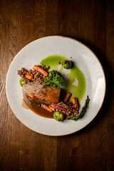 Top view on plate with piece of baked pork meat with buckwheat and vegetables