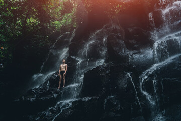 male standing at waterfall in Bali indonesia
