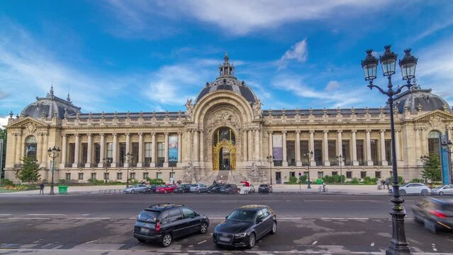 The exterior including the dome of the Petit Palais museum timelapse hyperlapse in Paris France. View from Grand Palais with parking and traffic on a road. Blue cloudy sky at summer day