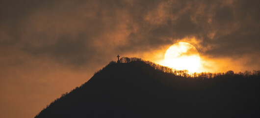 Image of the cross on top of Mount Musin&egrave; with a sun frame 