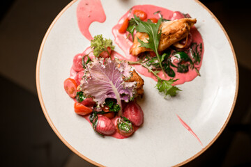 top view of tasty dish of pasta with tomatoes and fried chicken on plate