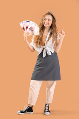 Female artist with paint color palettes pointing at something on beige background