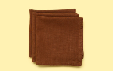 Folded napkins on yellow background