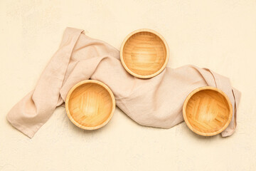 Composition with wooden bowls and napkin on light background