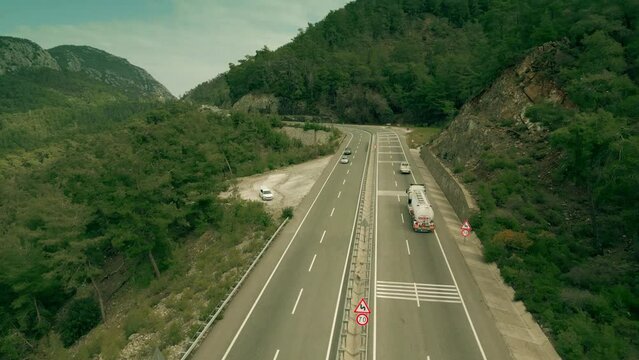 Gasoline tank truck driving along the modern mountain highway, aerial shot