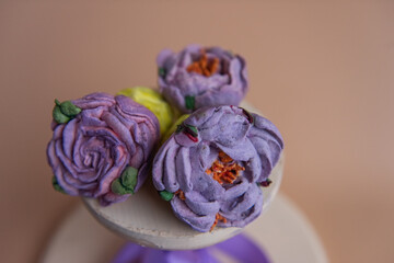 On wooden round background lie natural marshmallows in the form of purple peony flowers.