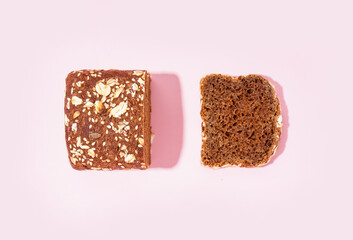 Sliced rye bread with various seeds on pink background